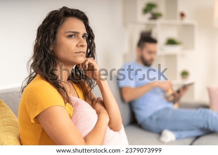 Focus on a serious woman thinking sitting on the sofa next to her partner Royalty-Free Stock Photo #2379073999