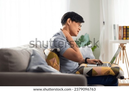 Office syndrome. Asian thai businessman suffering from shoulders neck and back pain after working long time at home office workplace Royalty-Free Stock Photo #2379096763