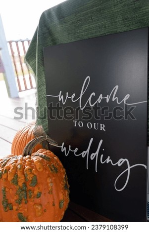 fall wedding welcome sign with a gourd and pumpkin outdoors