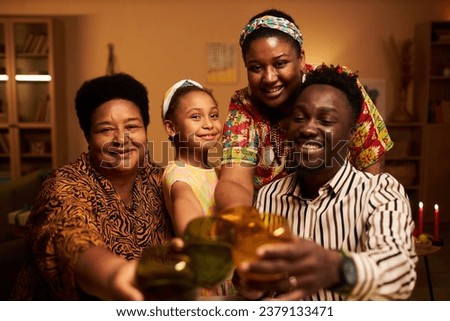 Joyful African-American family toasting when celebrating Kwanzaa holiday at home Royalty-Free Stock Photo #2379133471