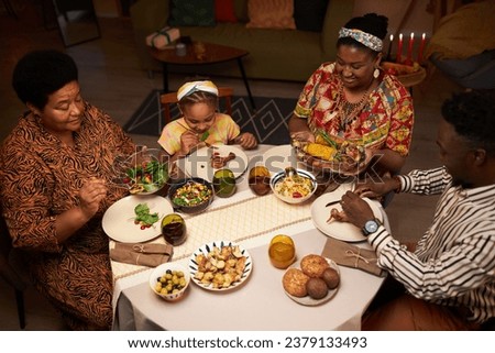 African-American family eating traditional dishes at Kwanzaa family dinner