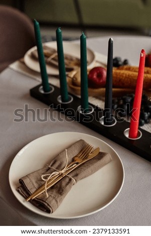 Dinner table served for family kwanzaa celebration with candle holder in the center