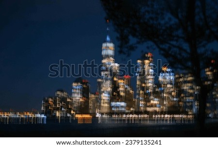 Defocused intentinal camera movement ICM gives this image a high energy dynamic night life feeling with colored lights and darkening sky. Urban city night background. Manhattan seen from Governor's