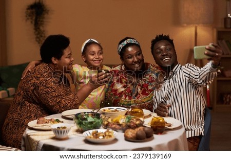 Joyful Black family video calling friends from another city when celebrating Kwanzaa