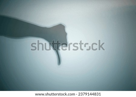 Shadow of a zombie's hand on a colored background. Scary Halloween concept