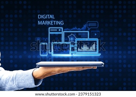 Close up of female hand holding smartphone with creative blue gadgets and business chart hologram on blurry pixel background. Digital marketing, finance, social network and online service concept