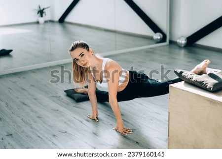 Female gymnast stretching legs with box