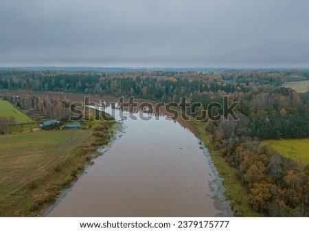 Flooded river with brown water in the countryside. Aerial view