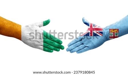 Handshake between Fiji and Ivory Coast flags painted on hands, isolated transparent image.