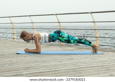 Woman on yoga mats on wooden floor at sea