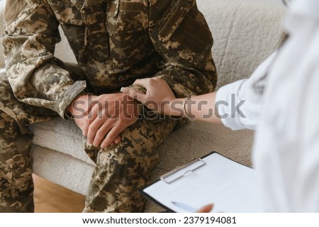 cropped shot of soldier and psychiatrist holding hands during therapy session Royalty-Free Stock Photo #2379194081