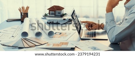 Interior architect designer at table designing hand drawing house interior blueprint sketch using architecture software, choosing mood board samples for modern precise house renovation design. Insight