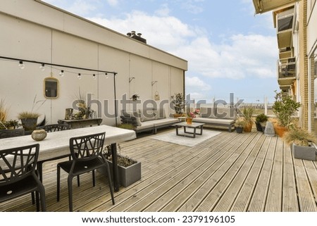 an outdoor living area with wood flooring and patio furniture on a sunny day in the photo is taken from outside
