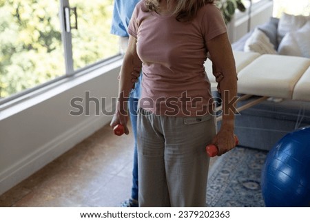 A nurse helps her patient exercise at home