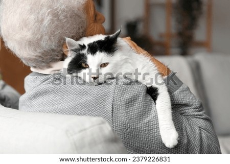 Senior woman with cute cat resting at home Royalty-Free Stock Photo #2379226831