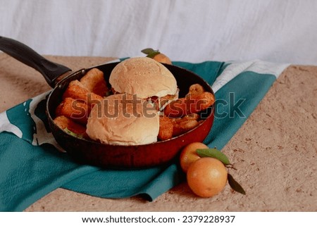 Homemade chicken burger, cheese sticks and fried wiener sausages on a pan, comfort food breakfast on a calm autumn morning Royalty-Free Stock Photo #2379228937