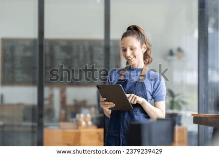 Startup successful small business owner sme beauty girl stand with tablet smartphone in coffee shop restaurant. Portrait of asian tan woman barista cafe owner. SME entrepreneur seller business concept Royalty-Free Stock Photo #2379239429