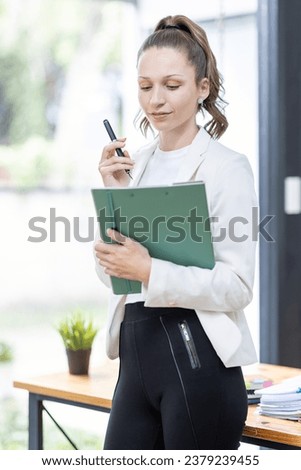 Smiling confident caucasian canada businesswoman auditor writing on clipboard, signing contract document in the office.