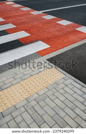 High angle view on pedestrian crossing with new white stripes on gray asphalt and bicycle lane in city street. Place to cross the road. Pavement and crosswalk with marking road Royalty-Free Stock Photo #2379240299