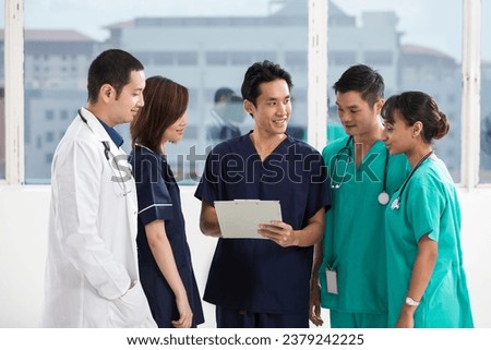Group of doctors and nurses standing in a hospital. Multi-ethnic team of caucasian, Chinese and indian medical staff. Royalty-Free Stock Photo #2379242225
