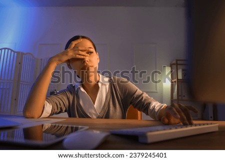 Tired young female programmer working in office at night