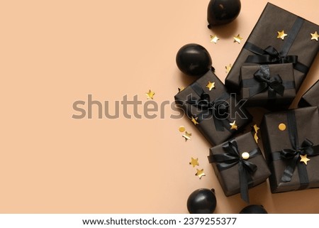 Gift boxes with balloons and confetti on beige background. Black Friday sale Royalty-Free Stock Photo #2379255377