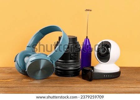 Modern gadgets on table near yellow wall Royalty-Free Stock Photo #2379259709