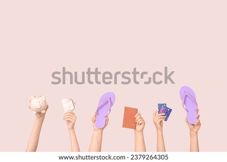 Female hands with piggy bank, flip flops, passport and credit cards on beige background. Travel concept Royalty-Free Stock Photo #2379264305