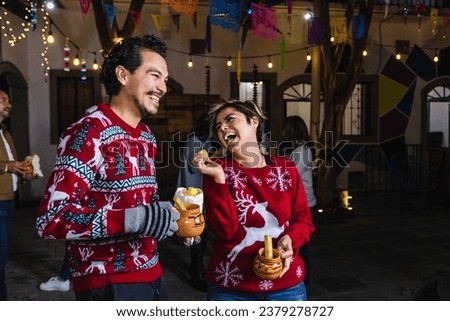 Mexican young couple or friends having fun in posada celebration for Christmas in Mexico Latin America	