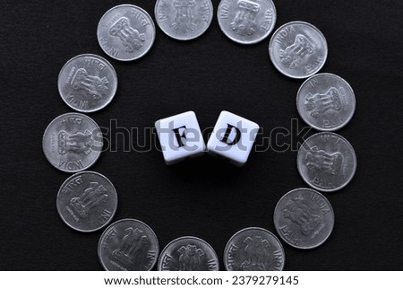 FD written in center with coins placed in circle over black background. Royalty-Free Stock Photo #2379279145