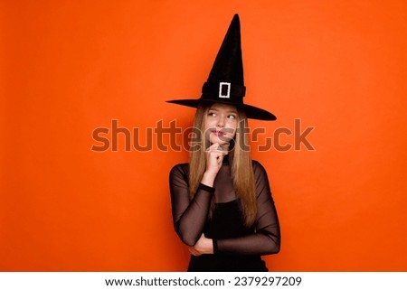 Photo of charming minded evil sorcerer girl arm touch chin look empty space brainstorming isolated on orange color background