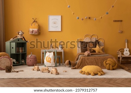 Warm and cozy child room interior with mock up poster frame, braided bed, gray desk with chair, wooden block toys, star pillow, plush dog, beige rug and personal accessories. Home decor. Template. Royalty-Free Stock Photo #2379312757