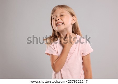 Suffering from allergy. Little girl scratching her neck on light gray background, space for text Royalty-Free Stock Photo #2379321147