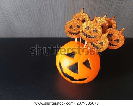 Halloween pumpkin heads inside bigger pumpkin head. Orange picture. Orange and black. Scary and funny. Trick or treat. Black table.