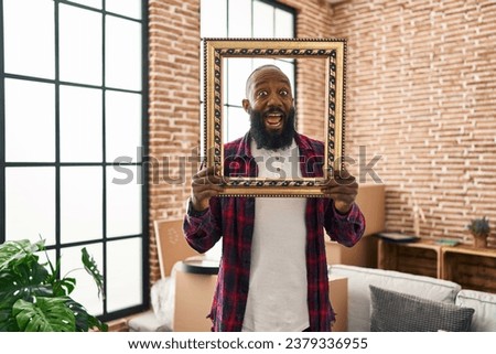 African american man putting face in empty frame celebrating crazy and amazed for success with open eyes screaming excited. 