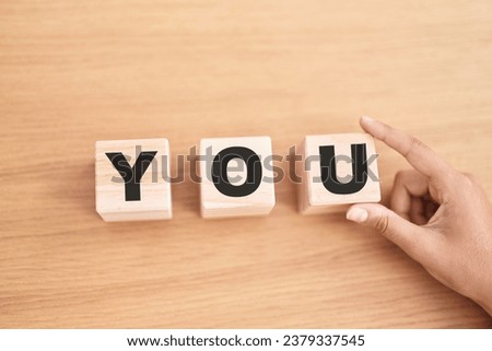 Woman hand holding cubes with you word on the table