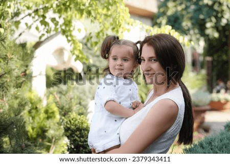 Happy mother with her cute daughter spending time together in park