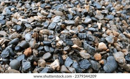 wet gravel close-up blurred along the edge of the picture, gray crushed rock mineral interspersed with various rocks, pebble texture wallpaper full frame, crushed stone as a building material