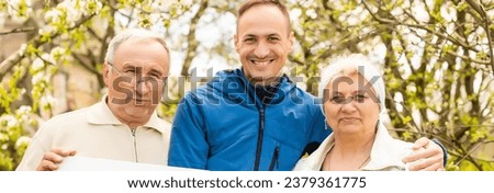 family holds holds photo canvas in the garden