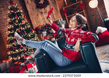 Full body cadre of joking video call girl brown hair lying chair at home atmosphere xmas tree lights buy gifts isolated on room background