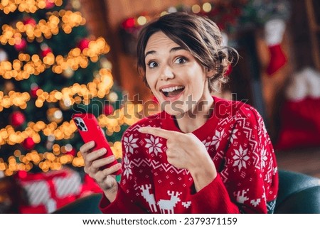 Portrait of attractive excited lady indicate finger hand hold smart phone order gifts shop festive illumination flat indoors