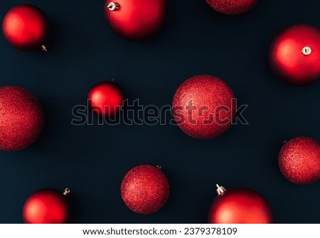 Red Christmas baubles decoration on black background. New Year party background. Minimal style. Creative Christmas or New Year concept. Fancy winter holidays pattern idea. Flat lay, top of view.