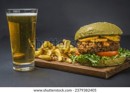 vegan burger with hogao and ripe plantain accompanied by french fries and beer