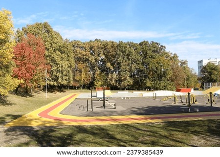 A skate park with trees and blue sky