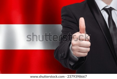 Austrian concept. Businessman showing thumb up on the background of flag of Austrian