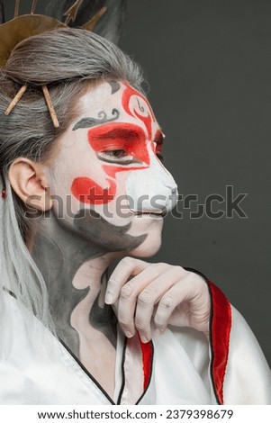 Pretty female face with Halloween makeup on black background, studio portrait closeup