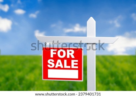 Beautiful green field and blue sky with FOR SALE sign