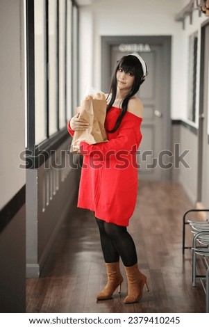 Portrait of a beautiful young woman Cosplay with red sweater with bread in shopping bag at corridor