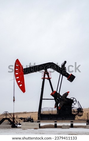 Vertical image of a working oil pump jack in Alberta, Canada 