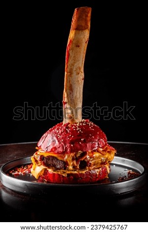 cheeseburger with beef rib meat, vegetables and cheese on dark background